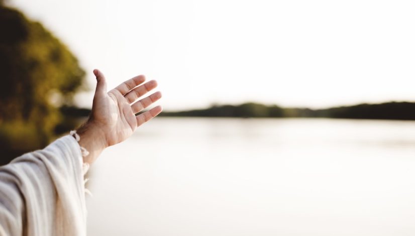 closeup-shot-person-wearing-biblical-robe-with-hand-up