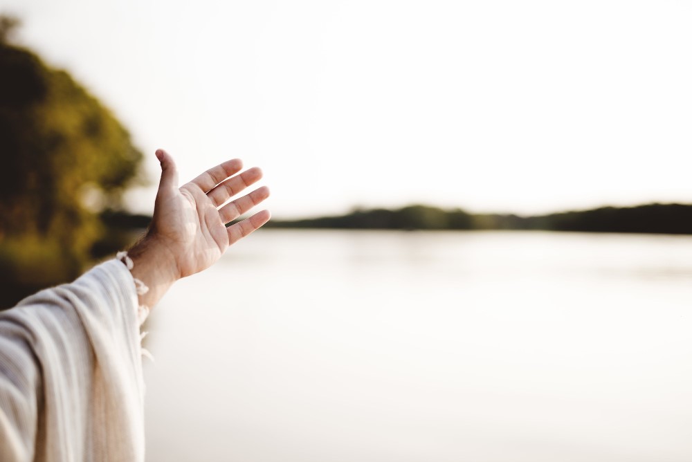 closeup-shot-person-wearing-biblical-robe-with-hand-up