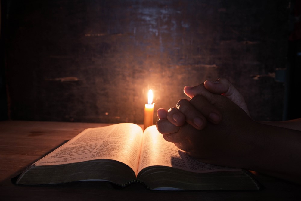 women-praying-bible-light-candles-selective-focus